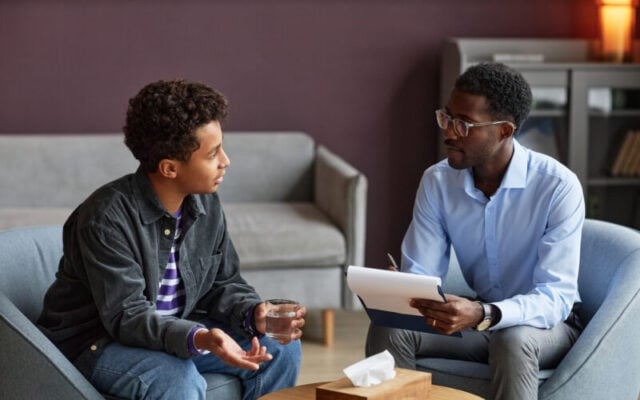 Teen boy talking to clinician